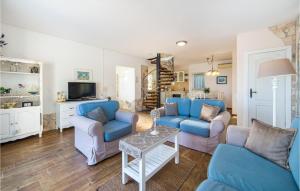 a living room with blue couches and a tv at Pet Friendly Home In Kremena With Outdoor Swimming Pool in Klek