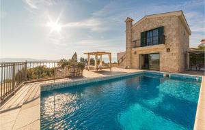 a villa with a swimming pool and a house at Nice Home In Kremena With 3 Bedrooms, Wifi And Outdoor Swimming Pool in Klek