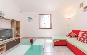 a living room with a couch and a tv at Awesome Apartment In Razanac With Wifi in Ražanac
