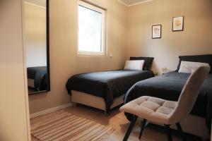 a bedroom with two beds and a mirror and a chair at Stijlvol ingerichte bungalow aan de Westerschelde in Baarland +42 photos