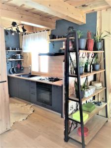a kitchen with a black shelving unit in a room at LES CHALET Kranjska Gora DUPLEX in Kranjska Gora