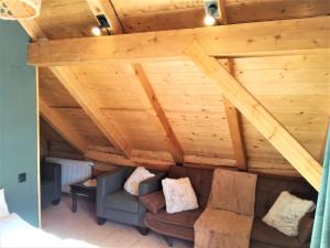 ein Wohnzimmer mit einem Sofa und Holzdecken in der Unterkunft LES CHALET Kranjska Gora DUPLEX in Kranjska Gora + 11 Fotos