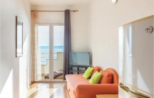 ジヴォゴシュチェにあるApartment Zivogosce 31のリビングルーム(オレンジ色のソファ、テレビ付)