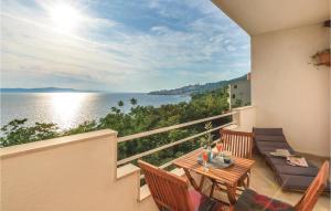 ジヴォゴシュチェにあるApartment Zivogosce 31の水辺の景色を望むバルコニー(テーブル、椅子付)