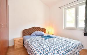 a bedroom with a bed with a blue comforter and a window at 2 Bedroom Gorgeous Apartment In Stomorska in Stomorska