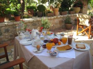 a table with breakfast foods and orange juice on it at Nostos Hotel in Galaxidi