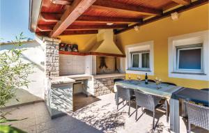 a patio with a fireplace and a table and chairs at Awesome Home In Perci With Wifi in Tar