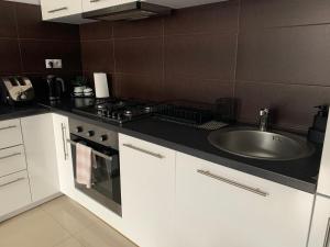 a kitchen with a sink and a stove at Apartament Abrahama 40 in Gdynia