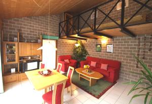 Verscio的住宿－格薩公寓，客厅配有红色的沙发和桌子