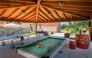 a patio with a pool table and two tables at 2 Bedroom Gorgeous Apartment In Hr-52215 Vodnjan in Vodnjan
