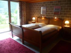 a bedroom with a bed and a large window at Casa Sot Gesa in Verscio