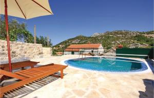 - une piscine avec un banc et un parasol dans l'établissement Stunning Home In Oslje With 3 Bedrooms, Wifi And Outdoor Swimming Pool, à Ošlje