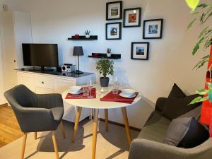 uma sala de estar com uma mesa e duas cadeiras e uma televisão em Ferien im Waldachtal em Waldachtal