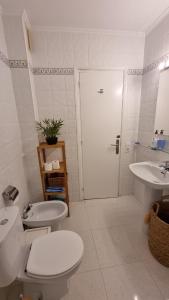 a white bathroom with a toilet and a sink at HOLIDAYS MENORCA Cala Galdana in Cala Galdana