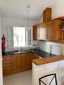 a kitchen with wooden cabinets and a window at HOLIDAYS MENORCA Cala Galdana in Cala Galdana
