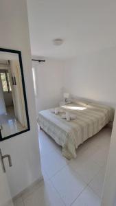 a bed in a white room with a mirror at HOLIDAYS MENORCA Cala Galdana in Cala Galdana