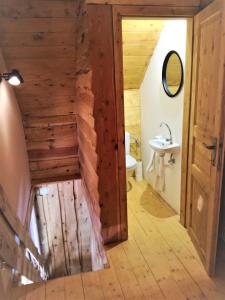 baño con paredes de madera, aseo y lavamanos en LES CHALET Kranjska Gora DUPLEX, en Kranjska Gora