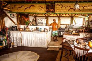 a man standing at the counter of a kitchen at Pousada Sabambugi in Baía Formosa