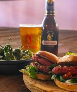 a plate of sausage sandwiches and a bottle of beer at Tabbu ibiza apartments in Playa d'en Bossa