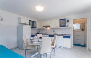 a kitchen with a table and chairs in a room at Amazing Apartment In Labin With Kitchen in Labin