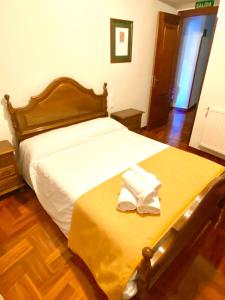 1 dormitorio con 1 cama grande con manta amarilla en Hostal Cristina en Estella