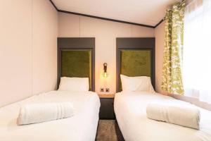 two beds sitting next to each other in a room at Fox Lodge with Hot Tub in York +8 photos