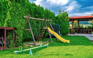 a playground with a slide in a yard at Hotel Stará škola na Šumavě in Hořice na Šumavě