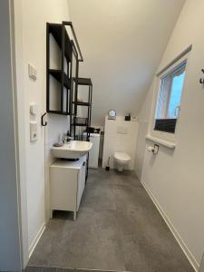a white bathroom with a sink and a toilet at Ferienwohnung Kirchblick in Hungen