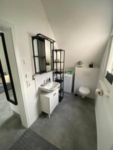 bagno bianco con lavandino e servizi igienici di Ferienwohnung Kirchblick a Hungen