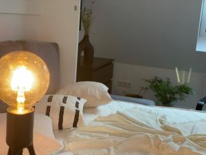 1 dormitorio con 1 cama con lámpara. en Ferienwohnung Kirchblick, en Hungen