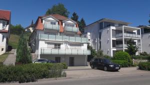 two cars parked in a parking lot in front of a building at Ferienwohnung mit Seeblick und PKW Abstellplatz am Haus in Überlingen