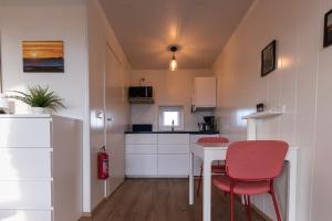 ヴォガルにあるReykjavík Outskirts - Minimalist Escapeの小さなキッチン(テーブル、赤い椅子付) +8枚の写真