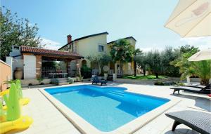 a swimming pool in the backyard of a house at Amazing Apartment In Kosinozici With 1 Bedrooms, Wifi And Outdoor Swimming Pool in Košinožići