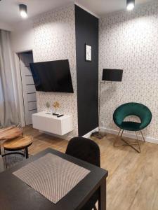 Televízia a/alebo spoločenská miestnosť v ubytovaní Apartament Premium