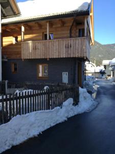 a wooden house with a fence in the snow at LES CHALET Kranjska Gora DUPLEX in Kranjska Gora