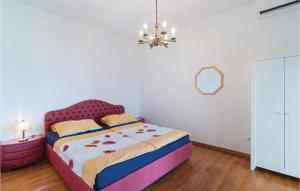 a bedroom with a bed and a chandelier at 2 Bedroom Lovely Apartment In Bol in Bol