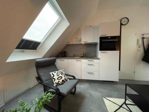 a living room with a chair and a kitchen at Ferienwohnung Kirchblick in Hungen