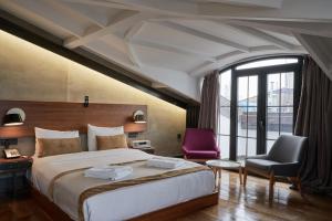 a bedroom with a large bed and a purple chair at Hotel The Public - Special Category in Istanbul