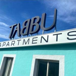 a sign on the side of a blue building at Tabbu ibiza apartments in Playa d'en Bossa