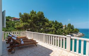 a wooden bench sitting on a balcony overlooking the ocean at Amazing Home In Blato With Wifi in Blato