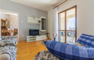 a living room with a couch and a tv at Nice Apartment In Stinjan With Outdoor Swimming Pool in Štinjan