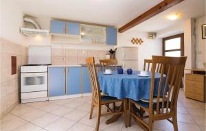 eine Küche mit einem Tisch und einem blauen Tischtuch in der Unterkunft Stunning Home In Veli Iz With 3 Bedrooms And Wifi in Veli Iž