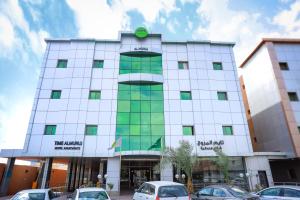 un edificio blanco con coches estacionados frente a él en Hospitality Path Serviced Apartments, en Riad