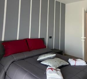 a gray bed with two pillows and a red headboard at L'ANGELICA AFFITTACAMERE in Grottaminarda +6 photos