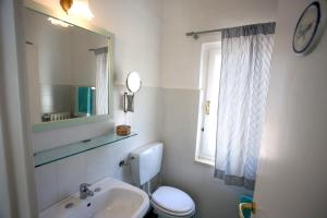 a bathroom with a sink and a toilet and a mirror at Ca' La Stella Sea-view Apartments in Porto Azzurro +62 photos