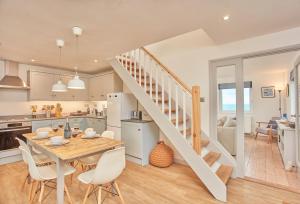 a kitchen and dining room with a table and a staircase at 3 Overcliff in Port Isaac