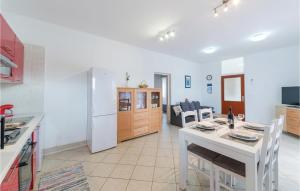 cocina y sala de estar con mesa blanca y sillas en Lovely Apartment In Veli Rat With Kitchen, en Veli Rat