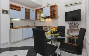 a kitchen with a glass table and black chairs at Stunning Apartment In Arbanija With House Sea View in Trogir