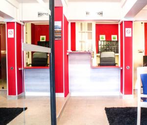 a view of a waiting room with red walls at Hotel Le Jardin in Lens