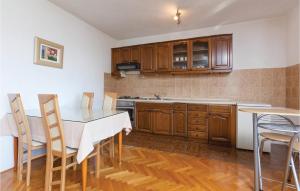 - une cuisine avec des placards en bois, une table et des chaises dans l'établissement Amazing Apartment In Podstrana With Wifi, à Podstrana